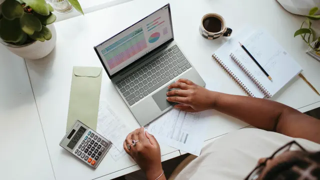 A laptop, calculator, and worksheet help break down the 10 10 80 rule.
