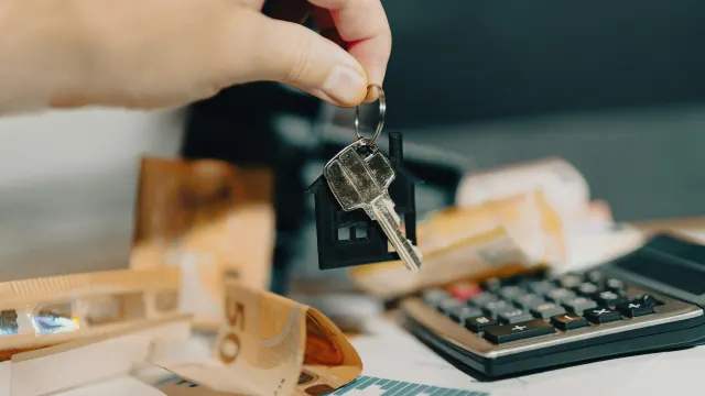 Small wooden boxes, cash, and a calculator show a 100 envelope money saving challenge.