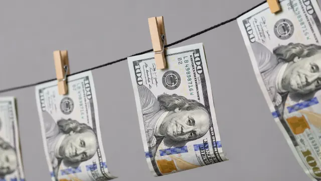 Dollar bills clipped in a row illustrate a biweekly money saving challenge.