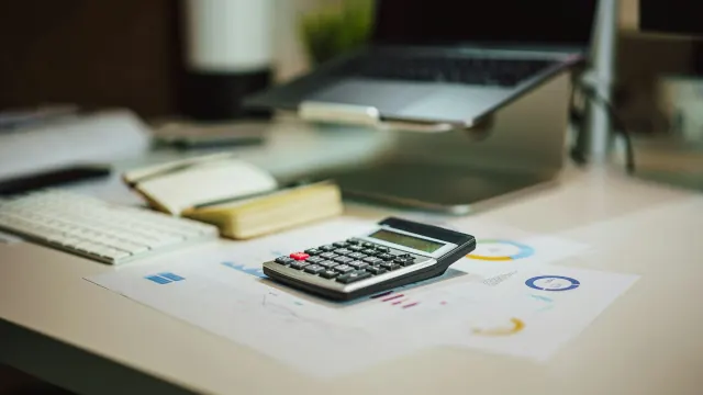 A clean desk with calculator and charts supports practical money management tips.