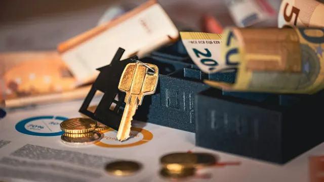 A locked cash box with coins and keys represents a money saving box.