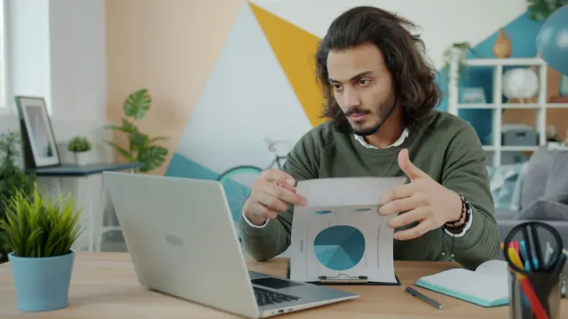 A man studies a pie chart on his laptop showing the connection between goals and savings.