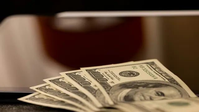 Stacks of dollar bills on a table show why is money considered so important.